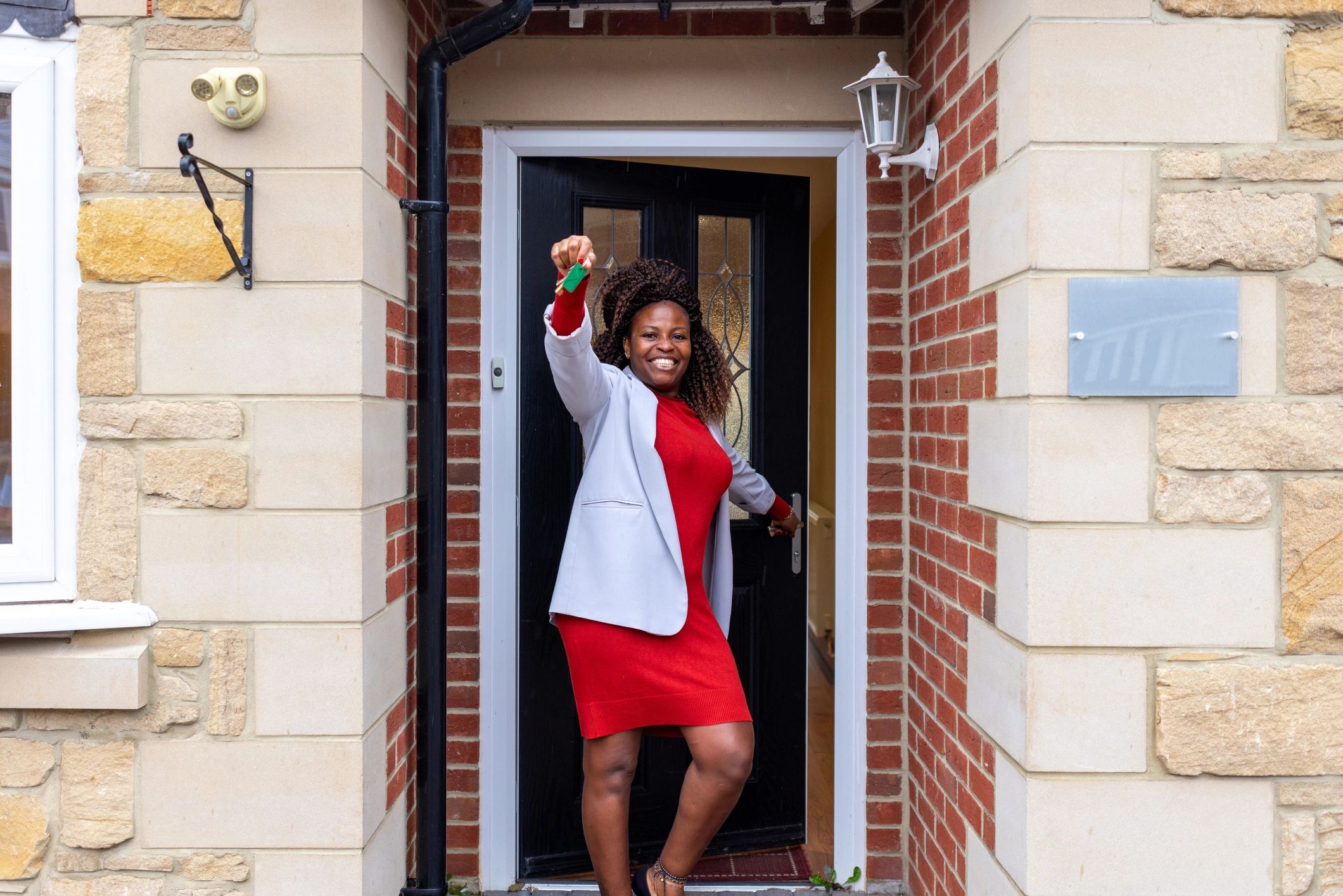 Real estate professional opening a front door and holding house keys